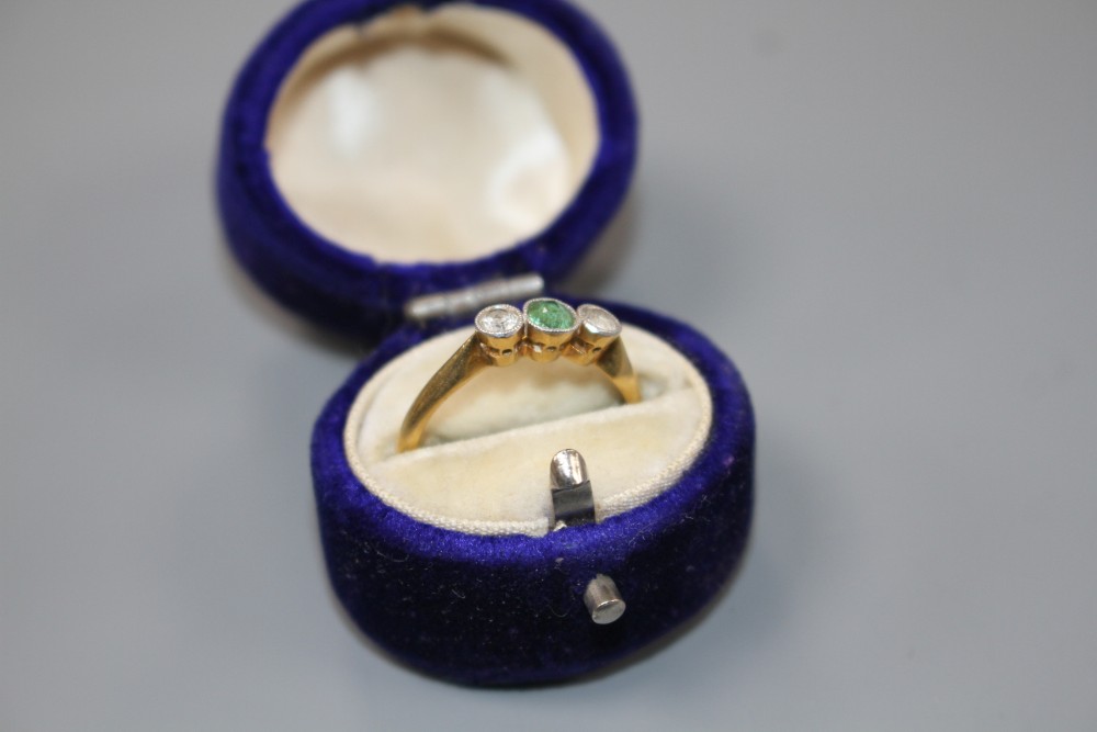 An 18ct and plat, green tourmaline and diamond set three stone ring, size M, gross weight 2.3 grams.